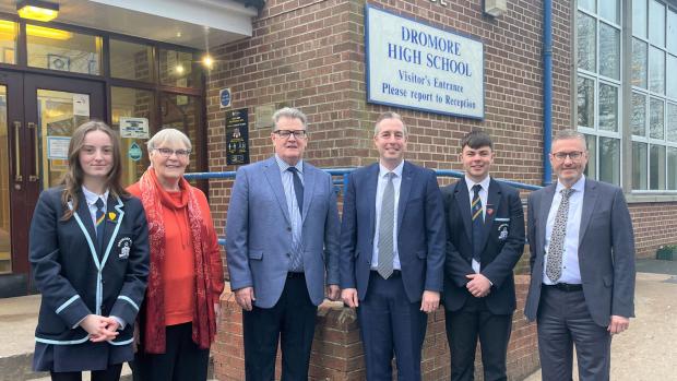 Picture of Education Minister Paul Givan, Principal Ian McConaghy, Board of Governors and pupils standing outside the front of Dromore High School