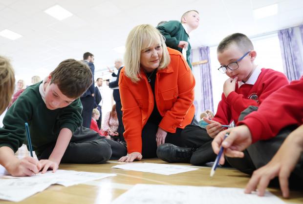 Minister pictured with pupils launching the Mainstreaming Shared Education Strategy