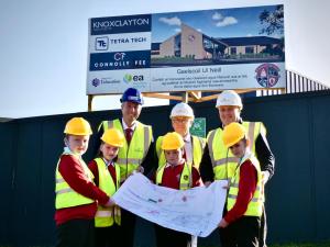 Image of Education Minister Paul Givan pictured at the Gaelscoil Uí Néill sod cutting ceremony with Principal, Conor McPhillips, Gerard Galvin, Chair of the Board of Governors and pupils.