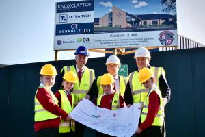 Image of Education Minister Paul Givan pictured at the Gaelscoil Uí Néill sod cutting ceremony with Principal, Conor McPhillips, Gerard Galvin, Chair of the Board of Governors and pupils.
